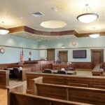Juror Offered “Asylum” in High-Profile Trial Empty courtroom with wooden benches and judge's bench