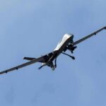 Drone Swarm Before Fighter Jet Fell military drone flying in a clear blue sky