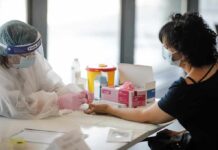Study Finds Toxic Metals in Maui Fire Survivors Healthcare worker performs finger-prick test on masked patient