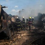 Explosion Rocks Ammo Plant Near Rome Firefighters amid twisted metal and smoke at a disaster site