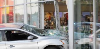 Silver car crashed into storefront window