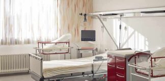A hospital room featuring empty patient beds and medical equipment