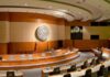 Interior view of a government chamber with wooden paneling and seating