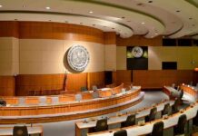 Interior view of a government chamber with wooden paneling and seating