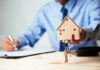 Minnesota Lets One Voter Vouch for 8 Hand holding a wooden house model with keys