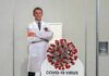 Delete Order Rocked Fauci’s Inbox Cardboard cutout of doctor with COVID-19 virus info display