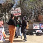 Professors Demand Stronger Math Standards protesters with signs at an outdoor student debt rally