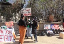 protesters with signs at an outdoor student debt rally