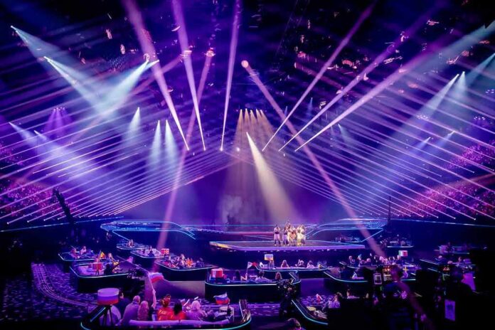 Concert stage with performers under purple laser lights
