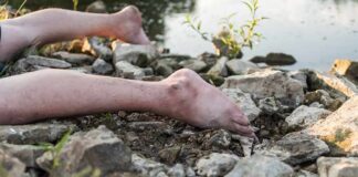 bare legs on rocky riverbank