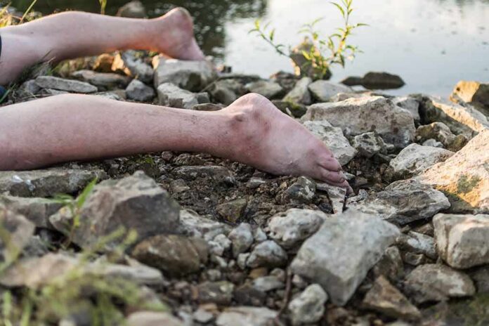 shutterstock_2056728158-1 bare legs on rocky riverbank