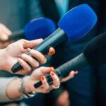 35-Year Veterans Affairs Error Could Reopen 90,000 Disability Claims Reporters holding colorful microphones