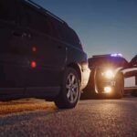 Rural Michigan Shooting Leaves Six Dead Police officer at patrol car during traffic stop at dusk