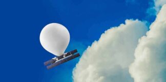 Weather balloon carrying solar-powered equipment near a large cloud