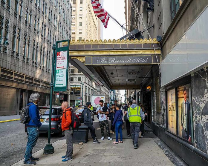 shutterstock_2307792205 Andreas Hestler and pedestrians outside The Roosevelt Hotel entrance on a city sidewalk
