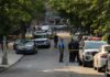 ICE Agent Shoots Man in Austin Police officers secure a residential street with patrol cars and yellow tape