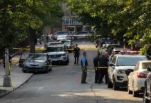 ICE Agent Shoots Man in Austin Police officers secure a residential street with patrol cars and yellow tape