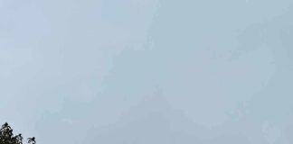 Hollywood sign partially hidden by fog on a hillside