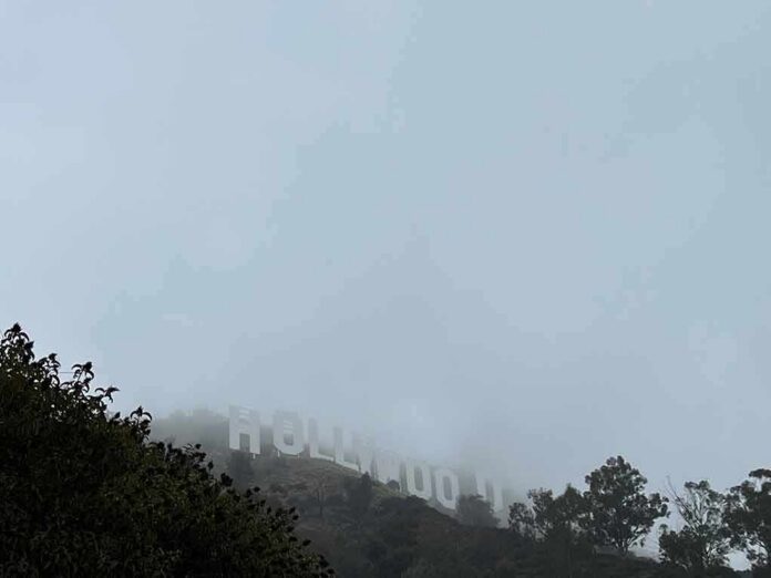 shutterstock_2350033123 Hollywood sign partially hidden by fog on a hillside