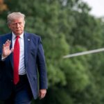Donald Trump walking outdoors and waving