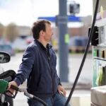 Gasoline Prices Surge as Strait of Hormuz Disruptions Man refueling a car at a gas station pump