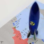 Blue toy rocket on a map of North Korea and surrounding countries
