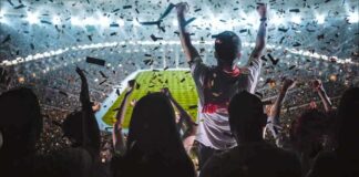 Fans celebrate in a packed stadium with confetti falling