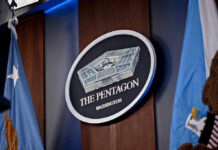 Trump Approves Military Firing Squad Execution The Pentagon emblem between two flags.