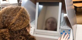 A person using an electronic voting machine at a polling station