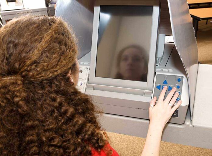 A person using an electronic voting machine at a polling station
