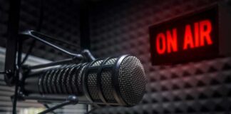 Close-up of a studio microphone with an illuminated on-air sign