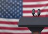 California Governor Debate Turns Personal Podium with microphones in front of a blurred American flag