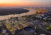 Saudi Oil Hub Hit by Drone Strikes Industrial oil refinery complex beside a river at dusk