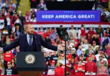 $4 Gas Sparks Backlash Over Trump’s Remarks Crowd at a political rally with a speaker at a podium; Stephen Paea, Curtis Lofton, Walter Jones, John Sullivan, and Colin David Jones present