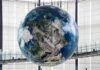 Military Move Ends in Historic Globe Damage Hanging digital Earth globe in modern atrium