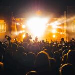 Crowd at a nighttime concert with bright stage lights