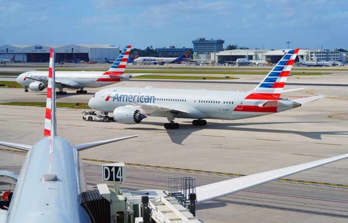 shutterstock_2152349011-1 American Airlines jets taxi at a busy airport apron