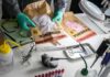 Forensic technician handling evidence bags on a lab table