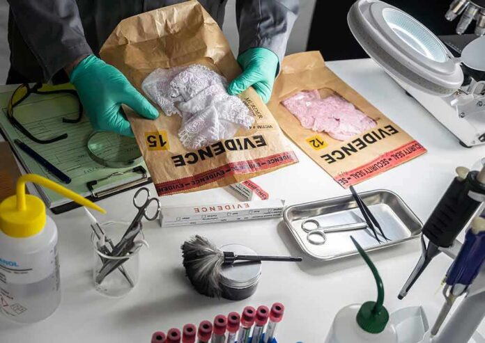 Forensic technician handling evidence bags on a lab table