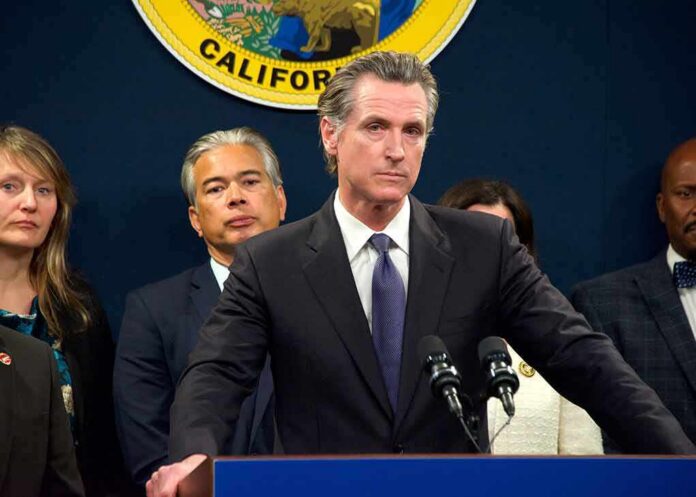 Gavin Newsom at a podium during a press conference with officials behind him