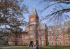 Historic university building with students walking in front during autumn