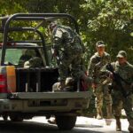 soldiers in camouflage near a military pickup truck