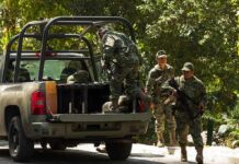 soldiers in camouflage near a military pickup truck